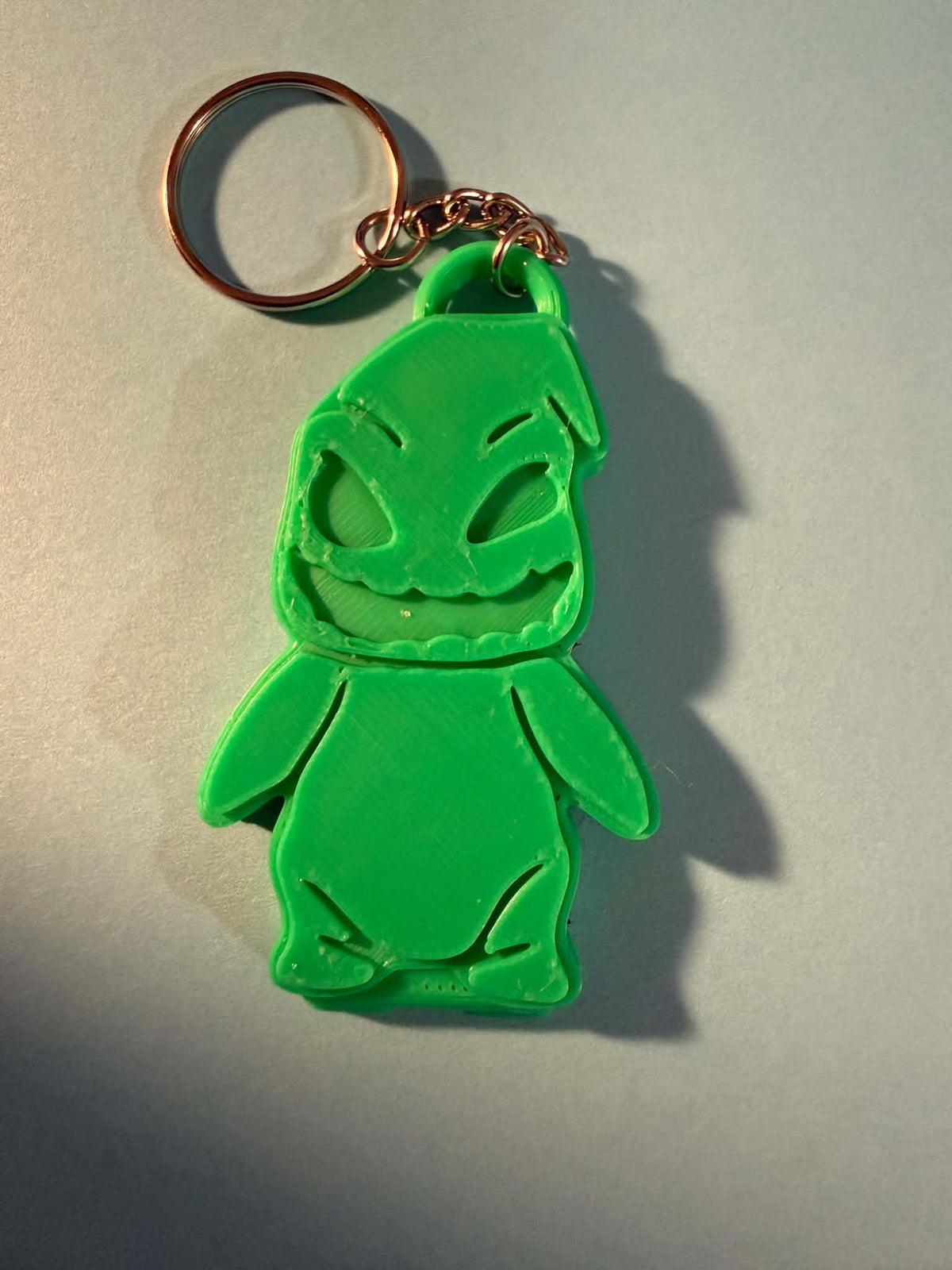 Green 3D printed spooky villain character keychain with gold ring