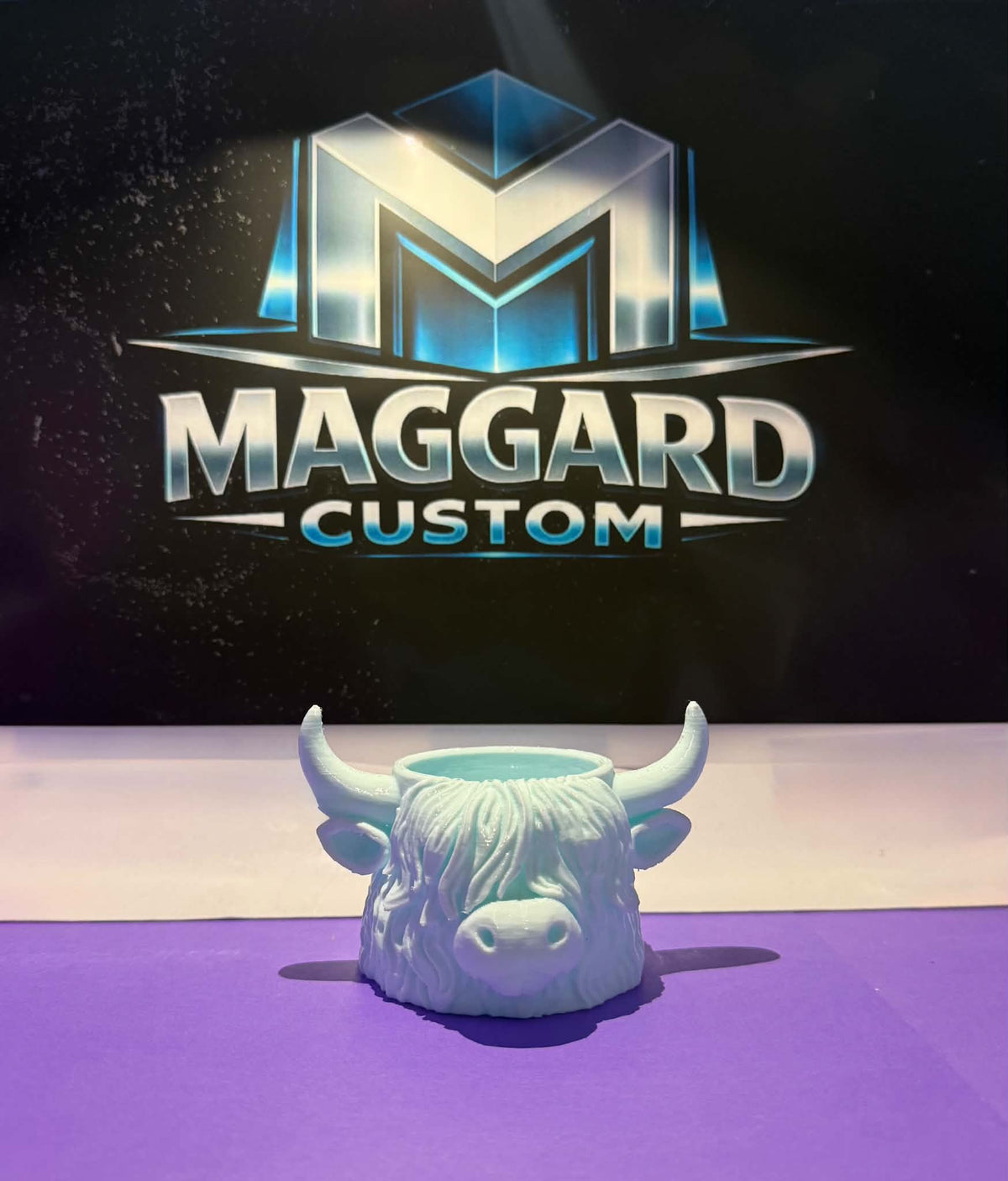 3D printed mint green highland cow head planter and trinket holder displayed in front of Maggard Custom logo