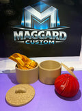 3D printed dumpling steamer basket set with bamboo-textured basket, lid, folded gold dumplings, red round dumpling, and chopsticks displayed in front of Maggard Custom logo