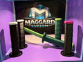 3D printed mid-size katanas with wrapped grips and display stands in black, green, and pink color combinations displayed in front of Maggard Custom logo