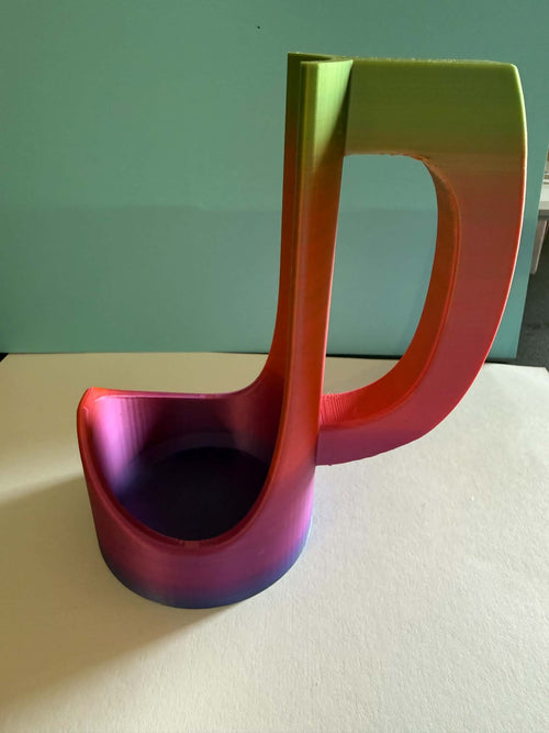 3D printed rainbow gradient energy drink can holder in a musical note shape