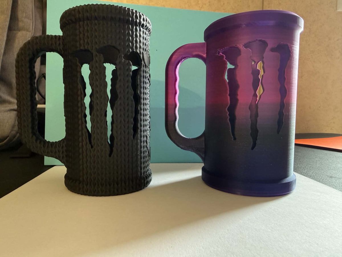 3D printed energy drink mugs with claw slash design in black textured and purple gradient finishes