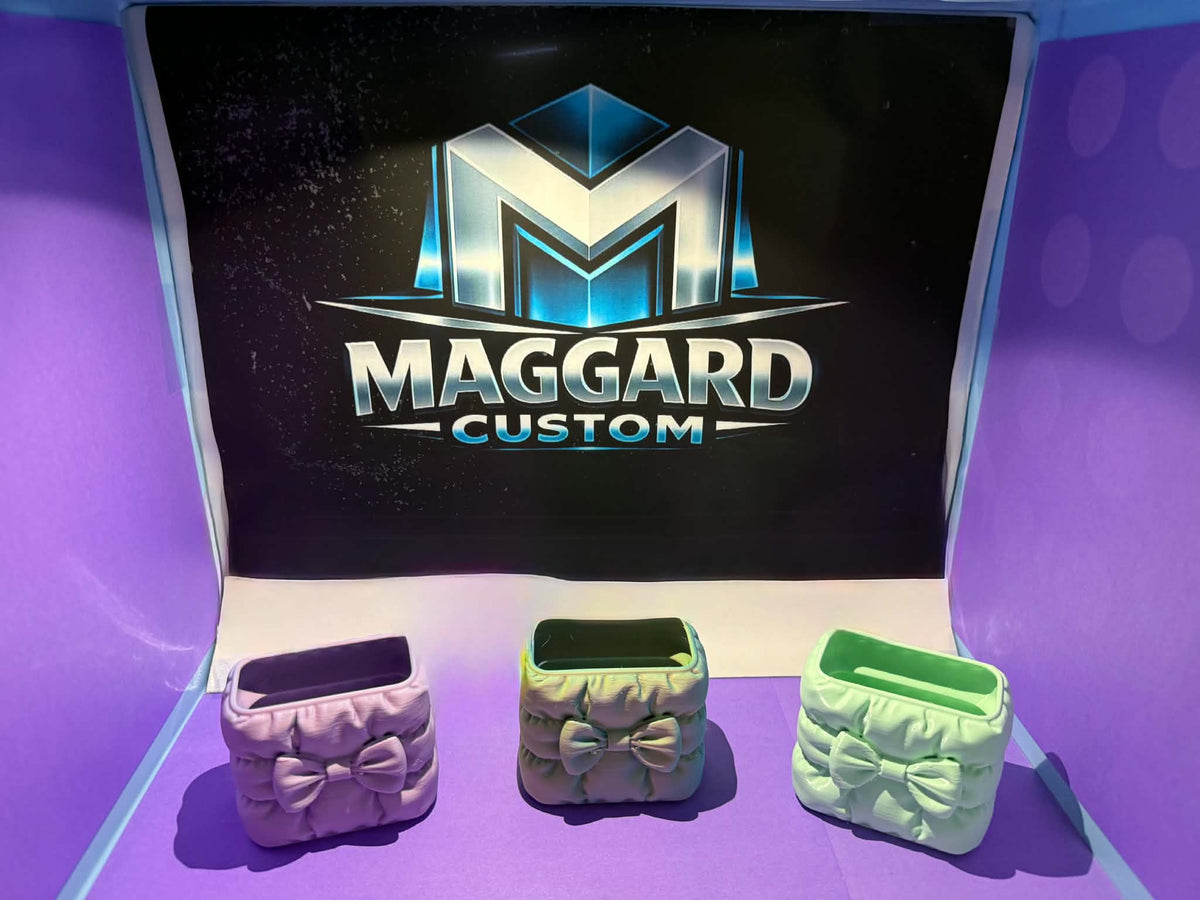 3D printed quilted bow mini organizer trinket holders in lavender, gray, and mint green colors displayed in front of Maggard Custom logo