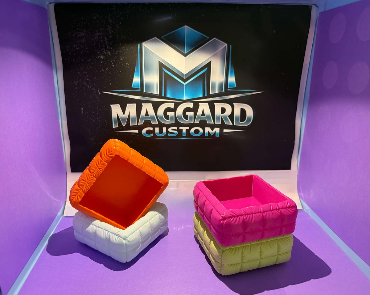 Set of 4 quilted 3D printed square trays in orange and pink color combinations displayed in front of Maggard Custom logo